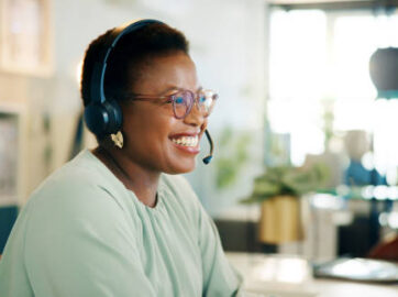 Laughing, agent or black woman in call center for consulting, questions or loan advice. Smile, sales advisor or happy African virtual assistant talking for telemarketing or communication in Nigeria